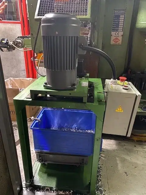 Equipo de manejo de scrap descargando recortes en un contenedor