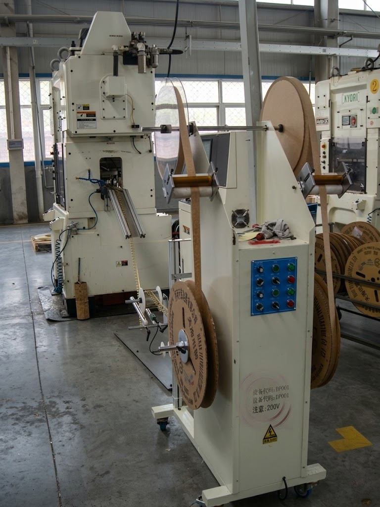 Rebobinador vertical con estaciones dispuestas al frente y atrás en un taller